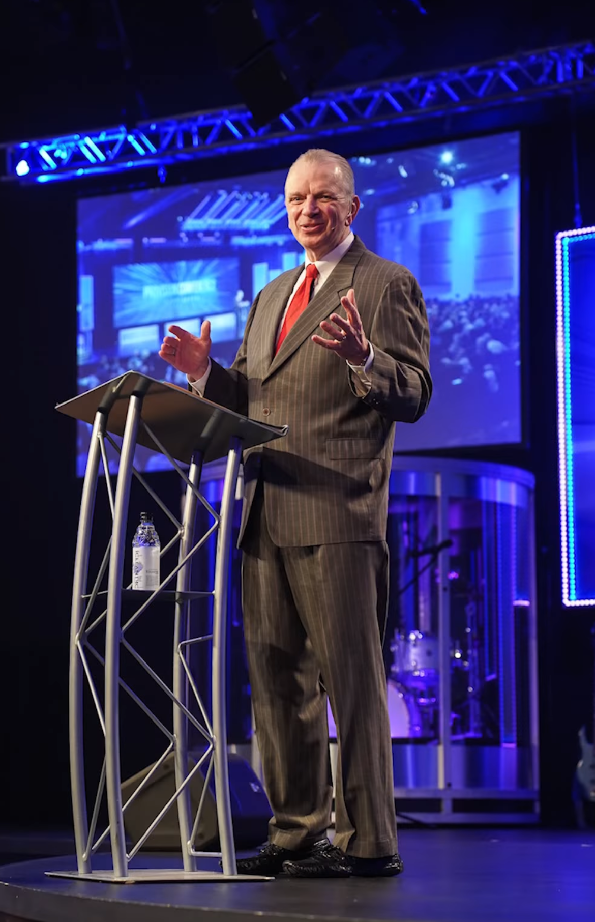 Dave Anderson speaking on stage at a private event